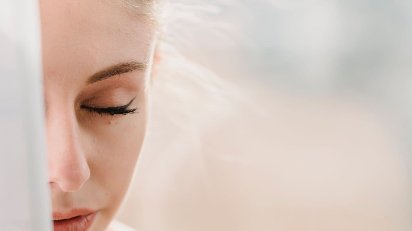 Personne assise près d'une fenêtre, les yeux fermés, en train de respirer calmement