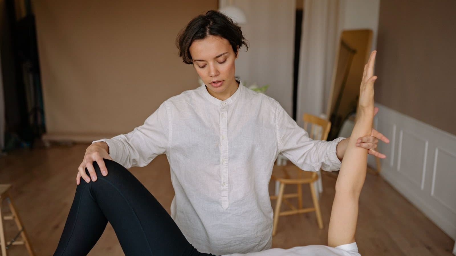 Bras tendu soutenu par la main d'un thérapeute lors d'un test musculaire
